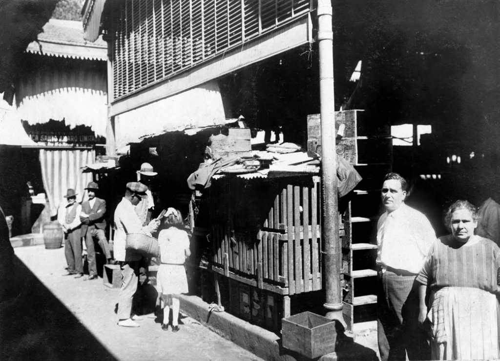 Inaugurado em 1907, o Mercado 25 de Março, localizado na rua de mesmo nome, era uma construção retangular, com boxes em alvenaria de tijolo e dividida em quatro pavilhões interligados no meio por uma pequena torre com um lanternim, “aber-tura destinada a garantir iluminação e ventilação ao ambiente”, segundo o livro Mercado Municipal de São Paulo – 70 anos de cultura e sabor, de Walter Falceta Júnior. Atualmente, no lugar do Mercado 25 de Março está a Praça Fernando Costa, no Centro Fotos: Arquivo CMSP